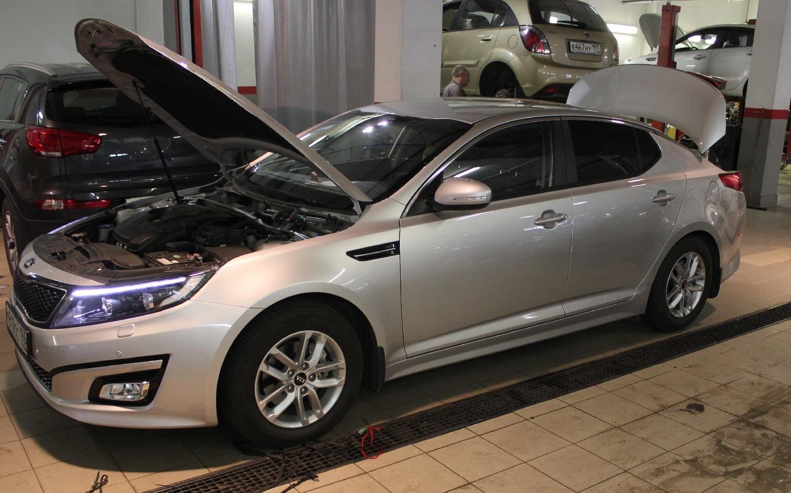 Киа с открытым капотом в сервисе